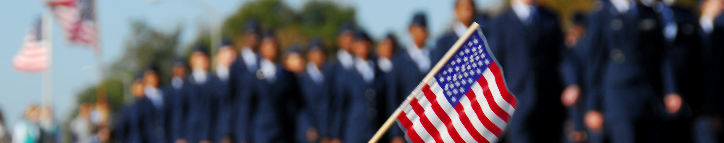 Veterans marching and little kids waving american flag on a stick