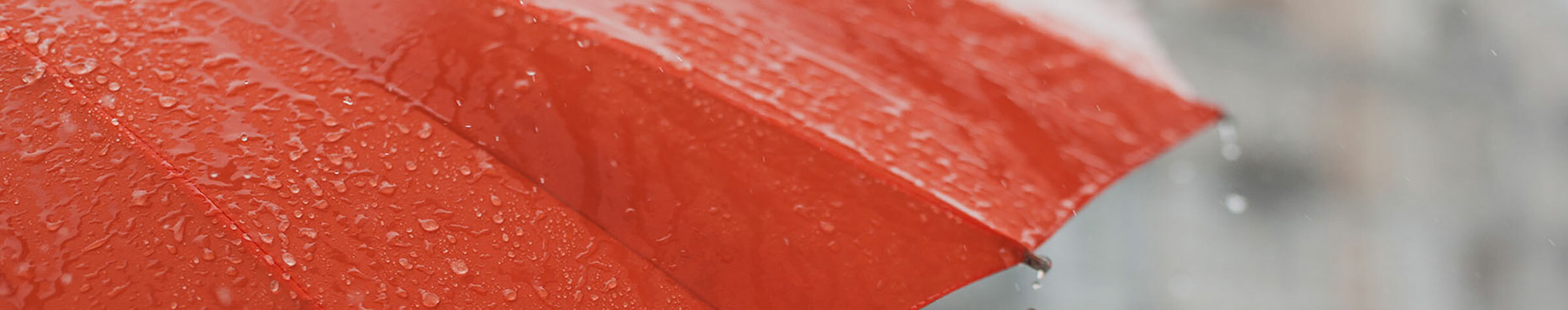 Red umbrella covered in rain